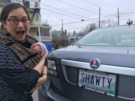  Em making a surprised face in front of a license plate that says "shawty"