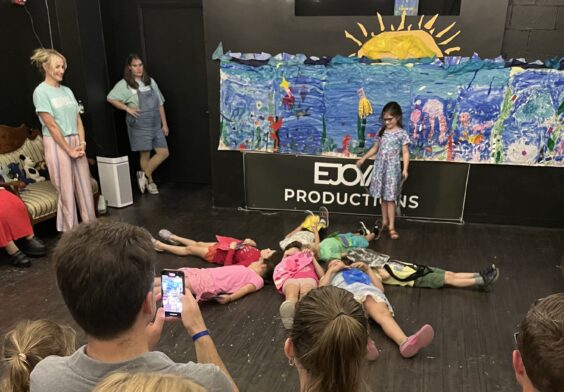 child performers lying on the floor in a star arrangement