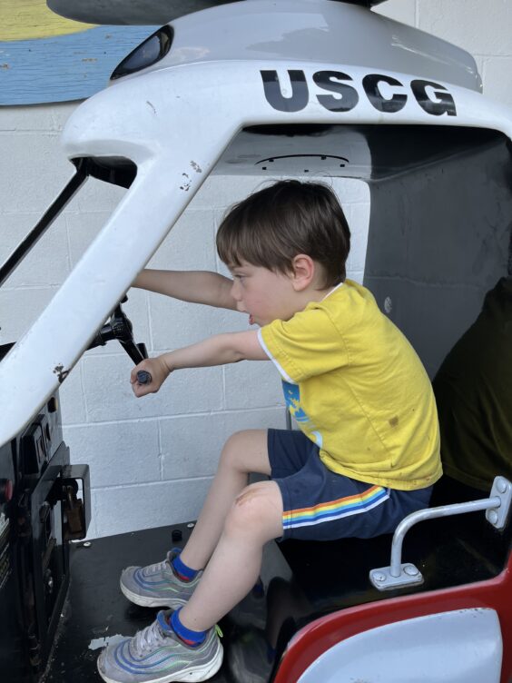 Myron in a coin-operated riding toy shaped like a helicopter